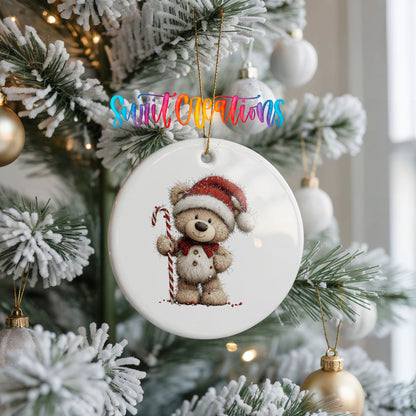teddy bear wearing a Santa hat and holding a candy cane ceramic Christmas ornament hanging on a frosted Christmas tree