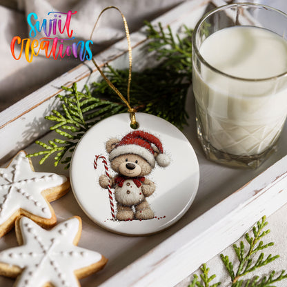 teddy bear wearing a Santa hat and holding a candy cane ceramic Christmas ornament styled with holiday cookies and a candle
