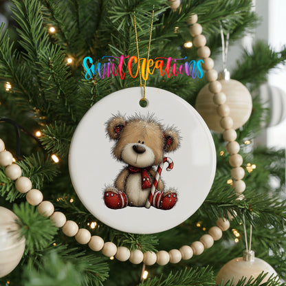 teddy bear with a candy cane and red Christmas ornament ceramic Christmas ornament hanging on a green Christmas tree