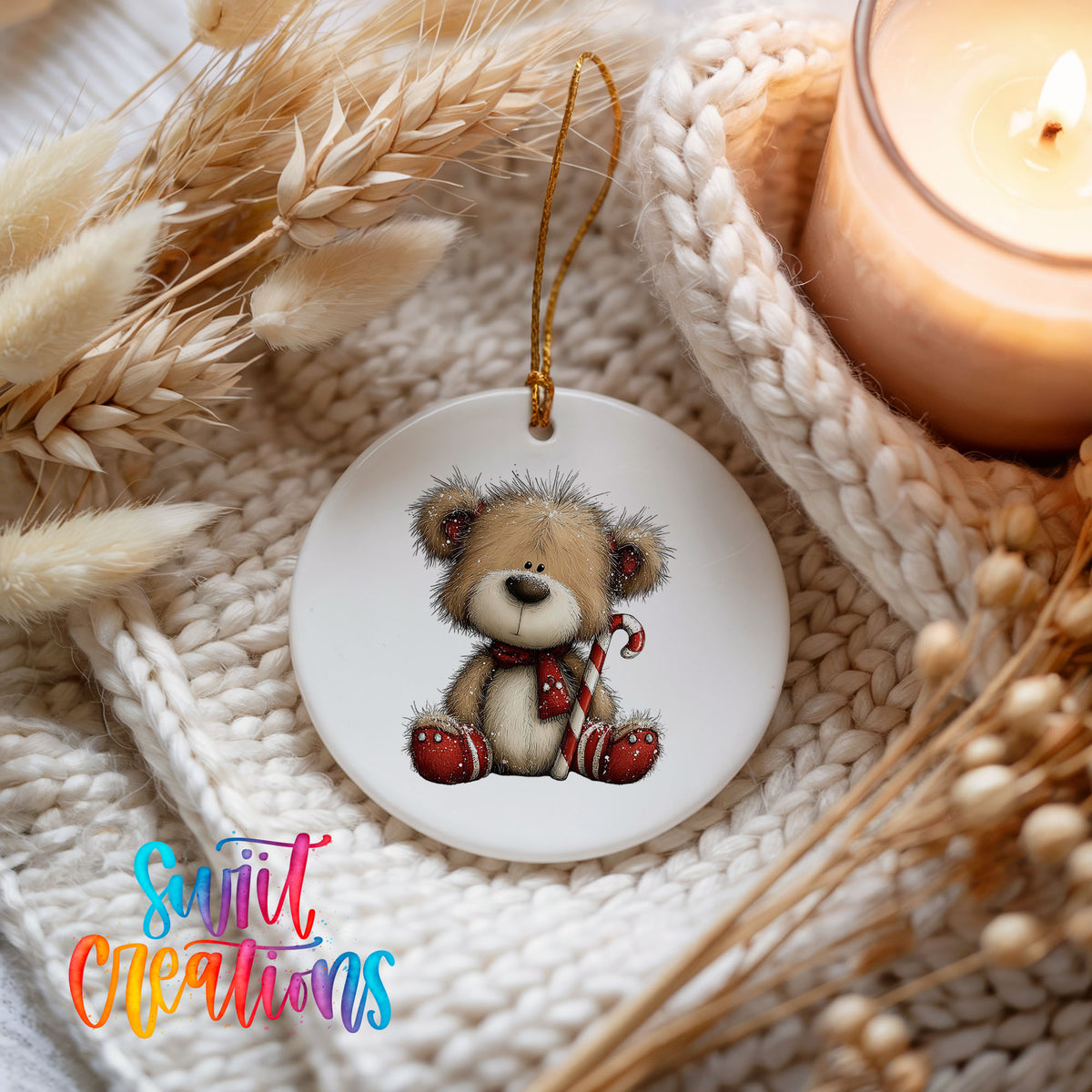 teddy bear with a candy cane and red Christmas ornament ceramic Christmas ornament styled on a cozy knit blanket