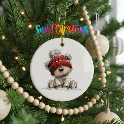 teddy bear in a red winter hat ceramic Christmas ornament hanging on a green Christmas tree