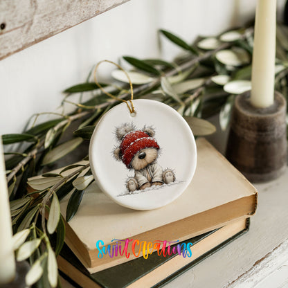 teddy bear in a red winter hat ceramic Christmas ornament styled on stacked books with greenery