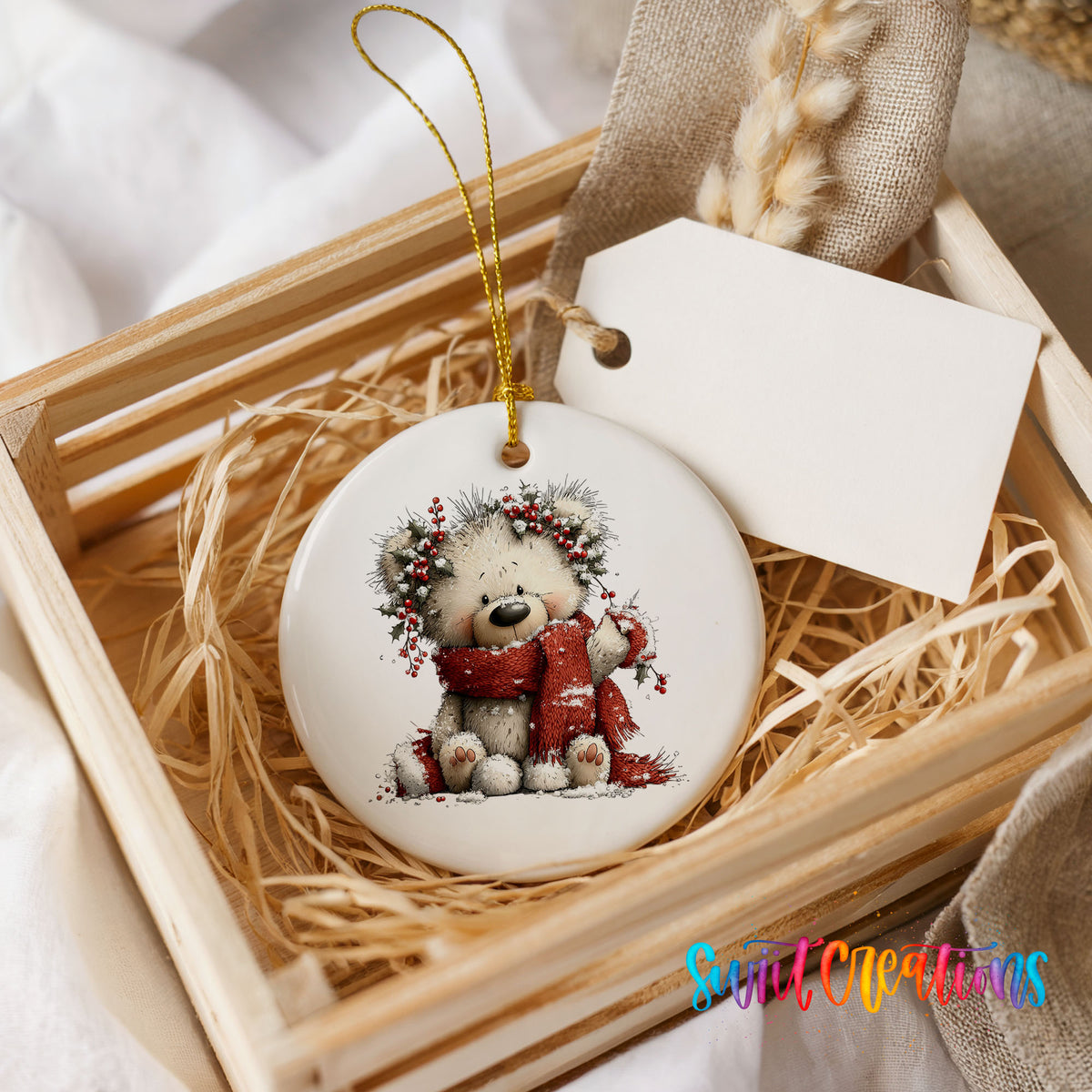 teddy bear with a red scarf and winter greenery ceramic Christmas ornament displayed in a wooden gift crate