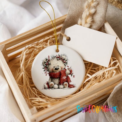 teddy bear with a red scarf and winter greenery ceramic Christmas ornament displayed in a wooden gift crate