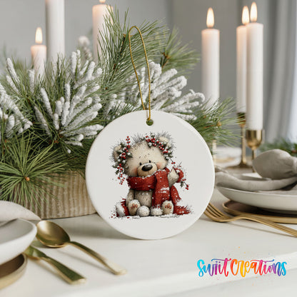 teddy bear with a red scarf and winter greenery ceramic Christmas ornament shown in a holiday table setting