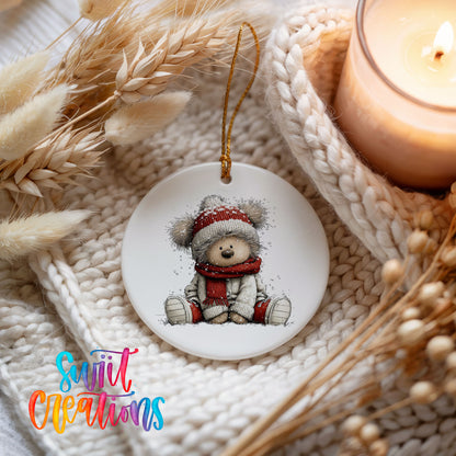 seated teddy bear in a red hat and scarf ceramic Christmas ornament styled on a cozy knit blanket