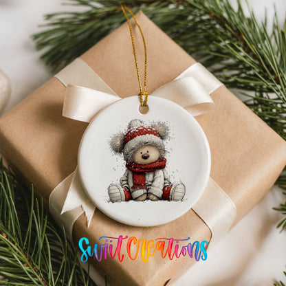 seated teddy bear in a red hat and scarf ceramic Christmas ornament displayed on a wrapped Christmas gift
