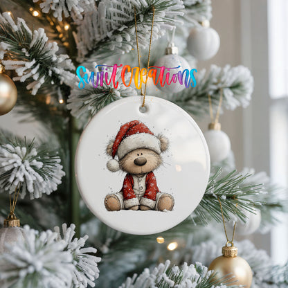 teddy bear in a Santa hat and red coat ceramic Christmas ornament hanging on a frosted Christmas tree