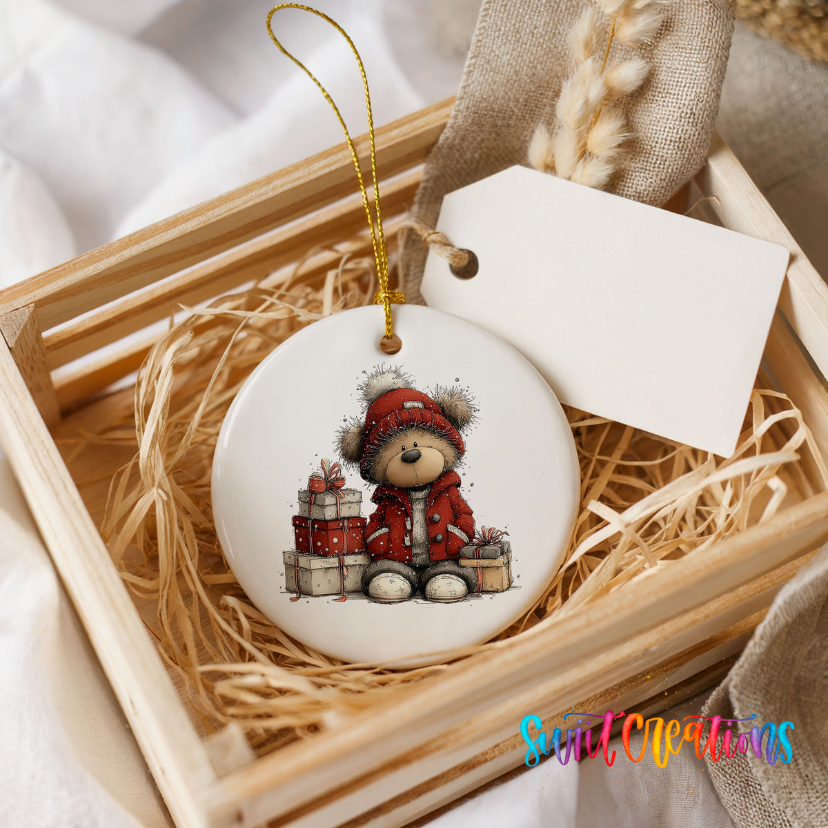 teddy bear in a red coat beside Christmas gifts ceramic Christmas ornament displayed in a wooden gift crate