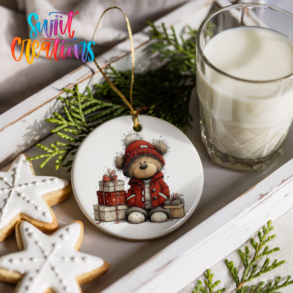 teddy bear in a red coat beside Christmas gifts ceramic Christmas ornament styled with holiday cookies and a candle
