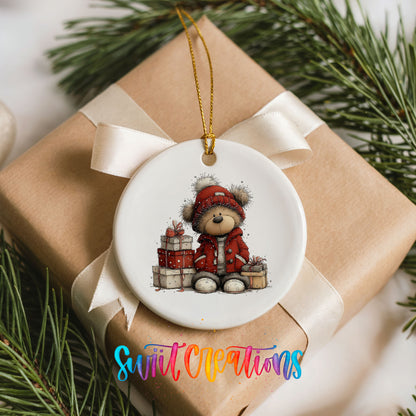 teddy bear in a red coat beside Christmas gifts ceramic Christmas ornament displayed on a wrapped Christmas gift