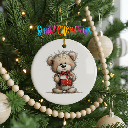 teddy bear holding a red Christmas gift ceramic Christmas ornament hanging on a green Christmas tree