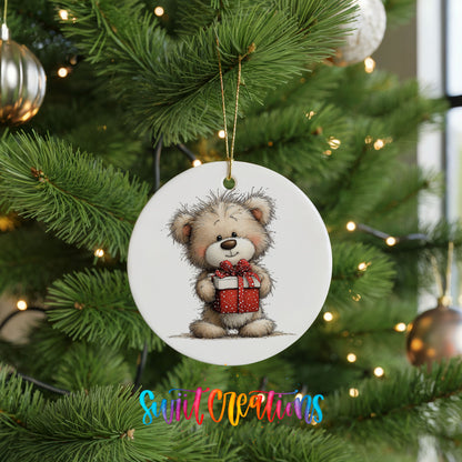 teddy bear holding a red Christmas gift ceramic Christmas ornament hanging on a lit Christmas tree
