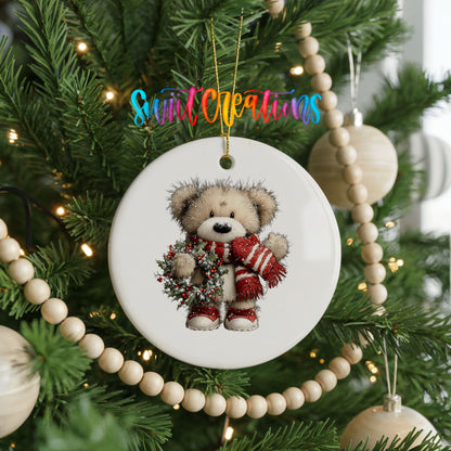 teddy bear with a red striped scarf and holly wreath ceramic Christmas ornament hanging on a green Christmas tree