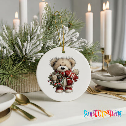 teddy bear with a red striped scarf and holly wreath ceramic Christmas ornament shown in a holiday table setting