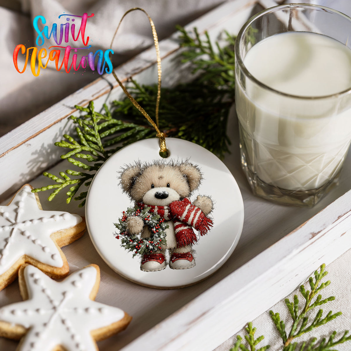 teddy bear with a red striped scarf and holly wreath ceramic Christmas ornament styled with holiday cookies and a candle