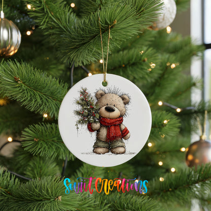 teddy bear in a red scarf holding a Christmas tree ceramic Christmas ornament hanging on a lit Christmas tree