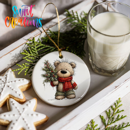 teddy bear in a red scarf holding a Christmas tree ceramic Christmas ornament styled with holiday cookies and a candle