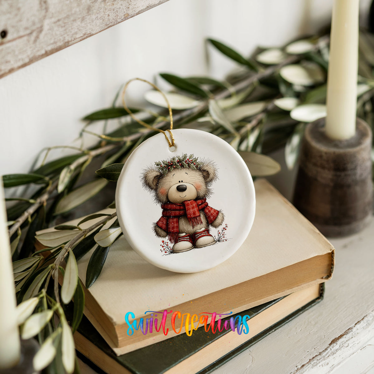 teddy bear in a red plaid scarf with holly ceramic Christmas ornament styled on stacked books with greenery