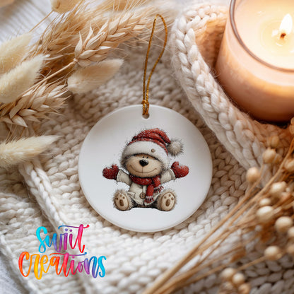 seated teddy bear in a Santa hat and red scarf ceramic Christmas ornament styled on a cozy knit blanket