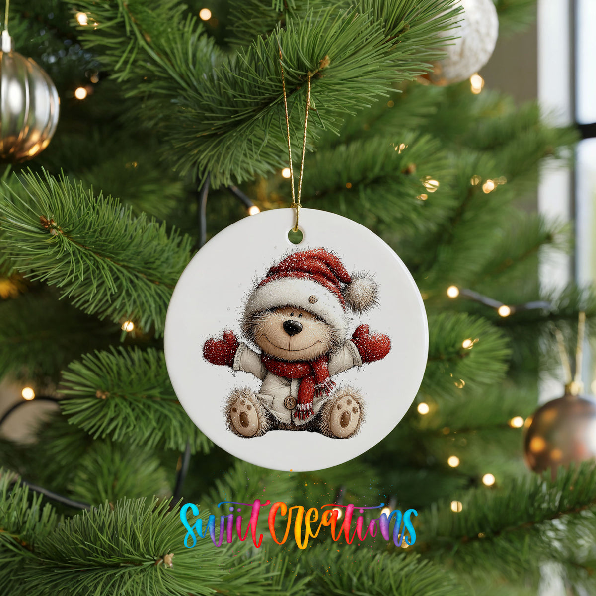 seated teddy bear in a Santa hat and red scarf ceramic Christmas ornament hanging on a lit Christmas tree