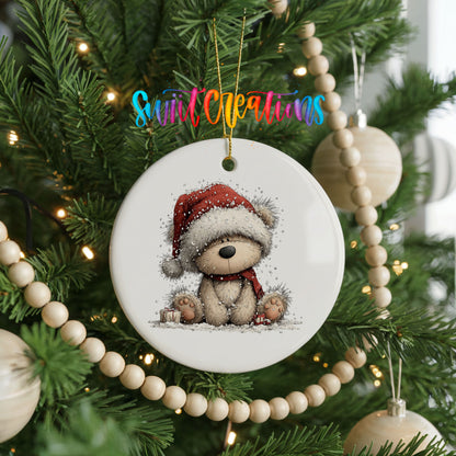 seated teddy bear in a red Santa hat ceramic Christmas ornament hanging on a green Christmas tree