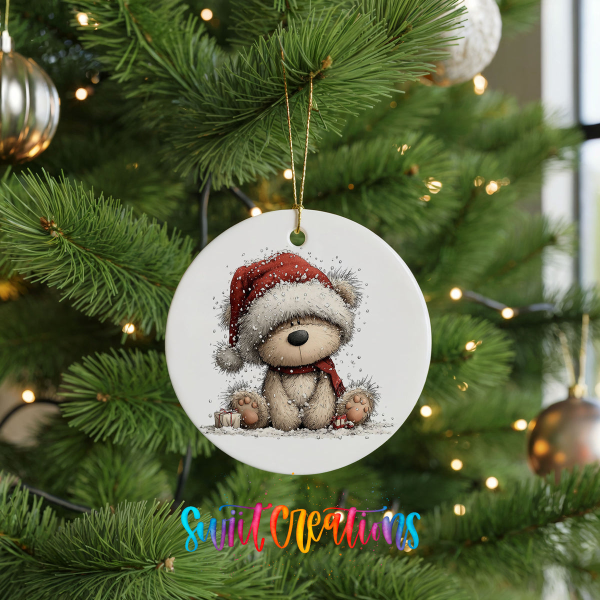 seated teddy bear in a red Santa hat ceramic Christmas ornament hanging on a lit Christmas tree