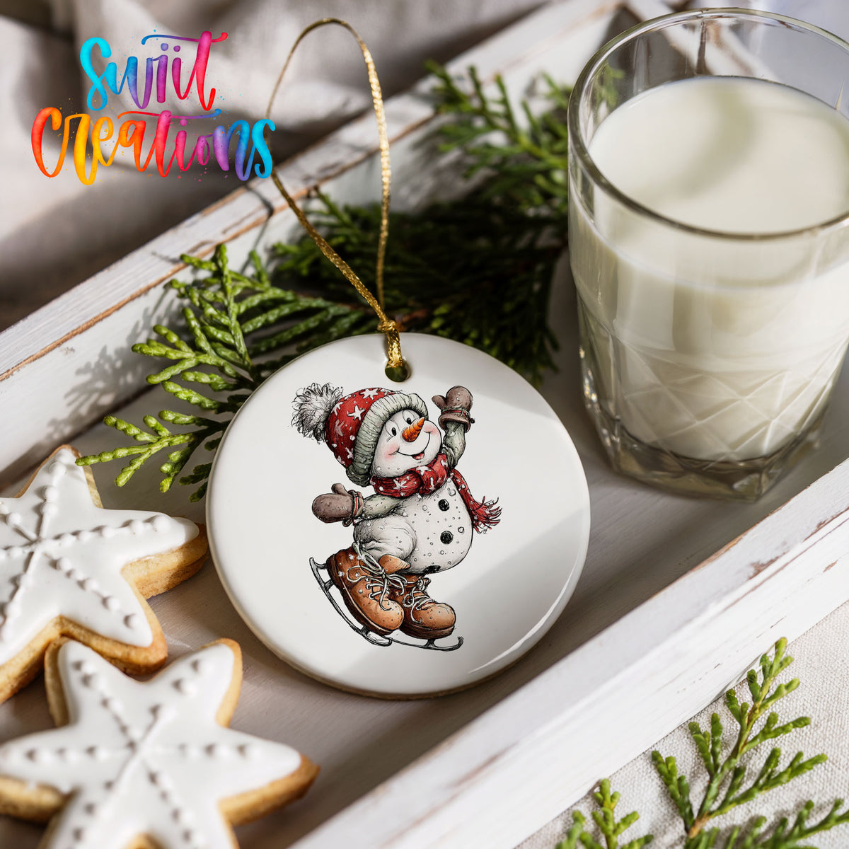 snowman ice skating in a red winter hat ceramic Christmas ornament styled with holiday cookies and a candle