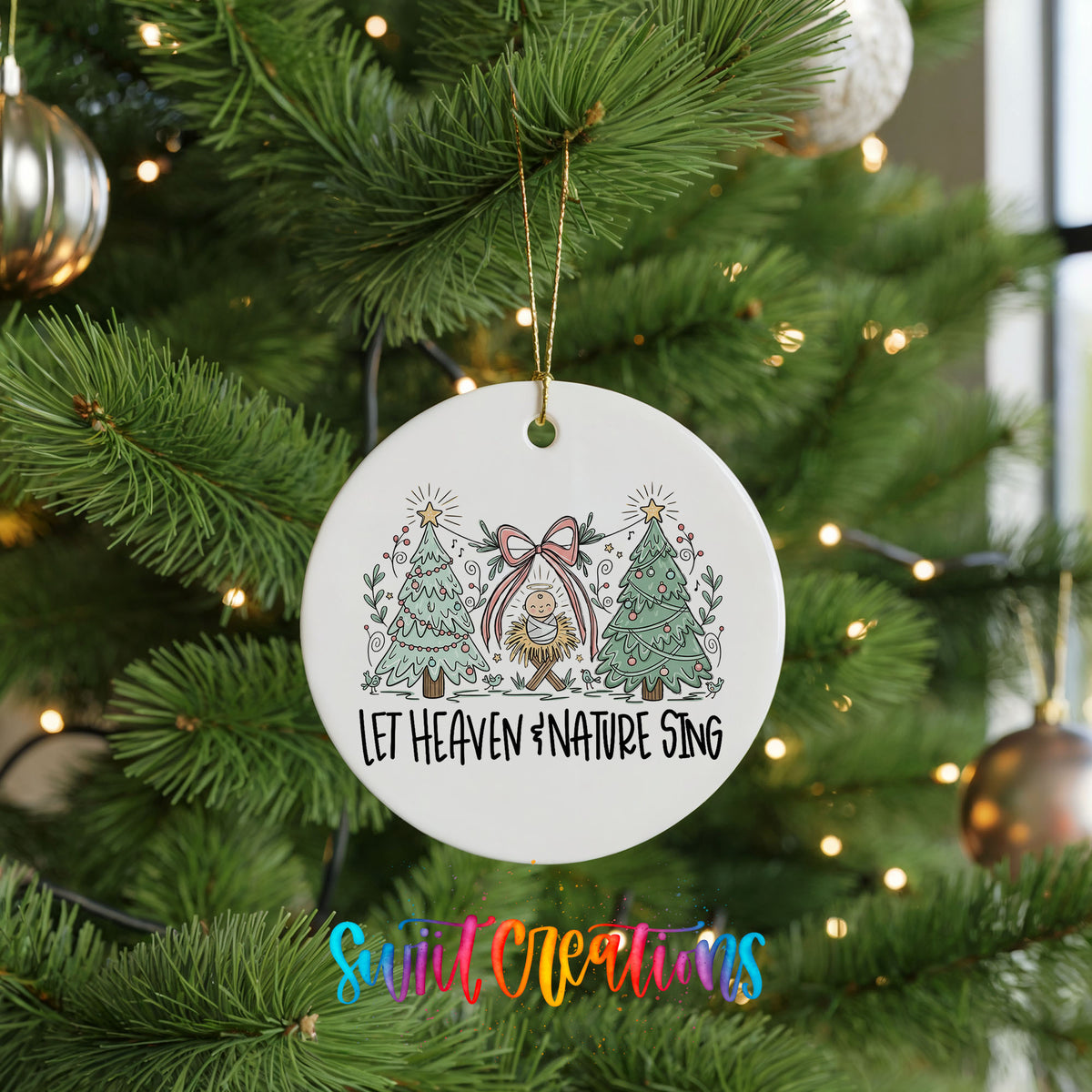 Let Heaven and Nature Sing church and winter trees design ceramic Christmas ornament hanging on a lit Christmas tree
