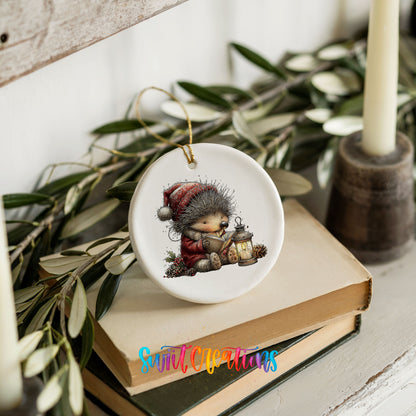 woodland bear in a Santa hat holding a lantern ceramic Christmas ornament styled on stacked books with greenery