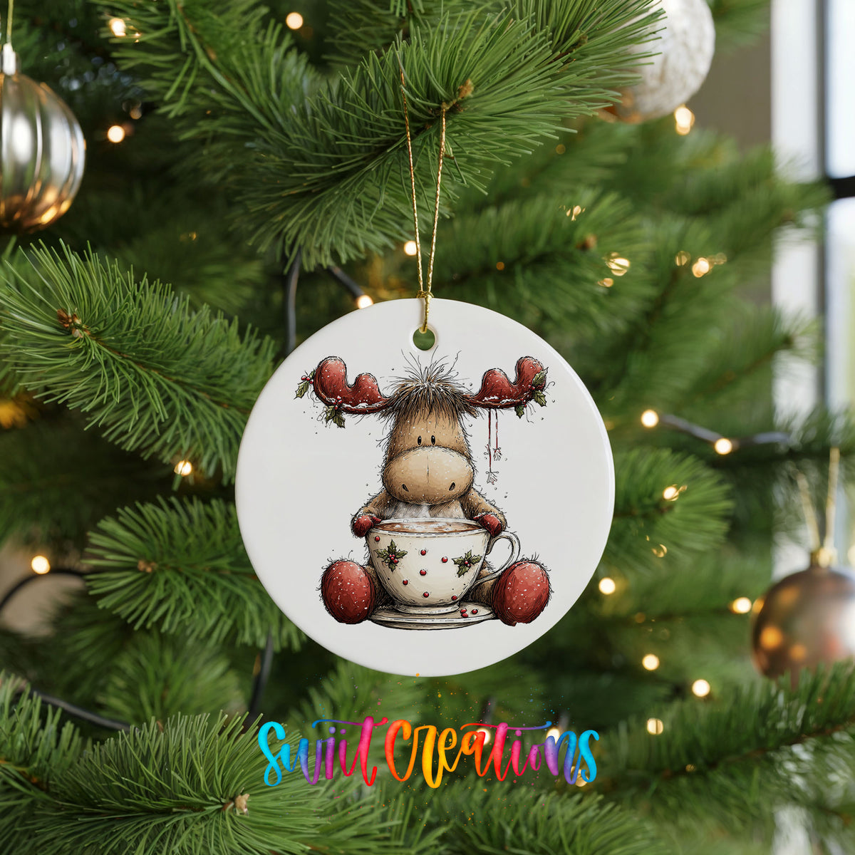 woodland moose in a snowman sweater ceramic Christmas ornament hanging on a lit Christmas tree
