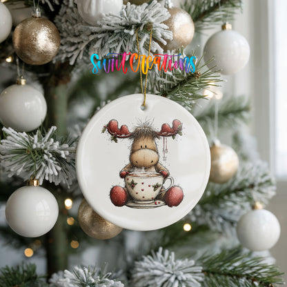 woodland moose in a snowman sweater ceramic Christmas ornament hanging on a frosted tree with ornaments