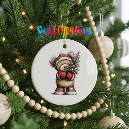 woodland bear in a Santa hat carrying a Christmas tree ceramic Christmas ornament hanging on a green Christmas tree