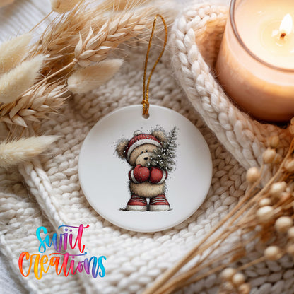woodland bear in a Santa hat carrying a Christmas tree ceramic Christmas ornament styled on a cozy knit blanket
