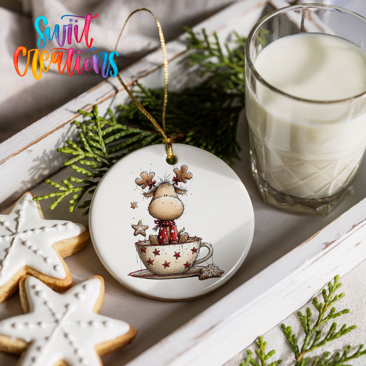 woodland reindeer sitting in a holiday teacup ceramic Christmas ornament styled with holiday cookies and a candle