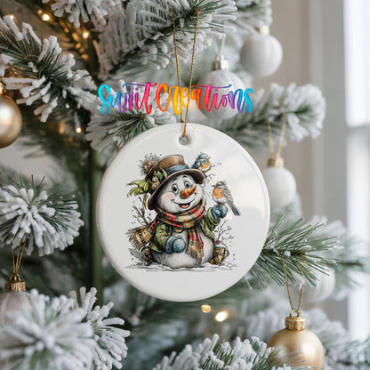 snowman in a brown hat with winter birds ceramic Christmas ornament hanging on a frosted Christmas tree