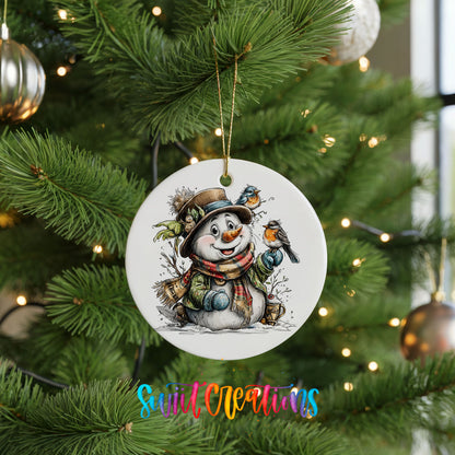 snowman in a brown hat with winter birds ceramic Christmas ornament hanging on a lit Christmas tree