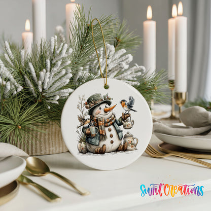 snowman with a lantern and winter birds ceramic Christmas ornament shown in a holiday table setting