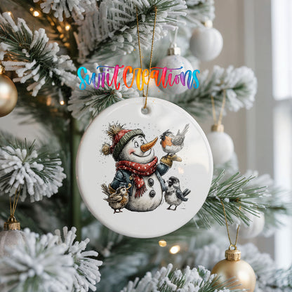 snowman in a red scarf surrounded by birds ceramic Christmas ornament hanging on a frosted Christmas tree