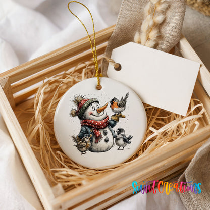 snowman in a red scarf surrounded by birds ceramic Christmas ornament displayed in a wooden gift crate