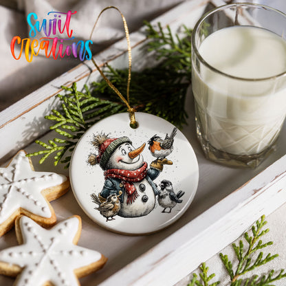snowman in a red scarf surrounded by birds ceramic Christmas ornament styled with holiday cookies and a candle