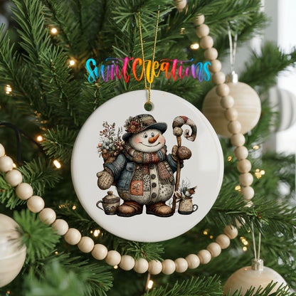 snowman in a brown winter hat holding a candy cane ceramic Christmas ornament hanging on a green Christmas tree