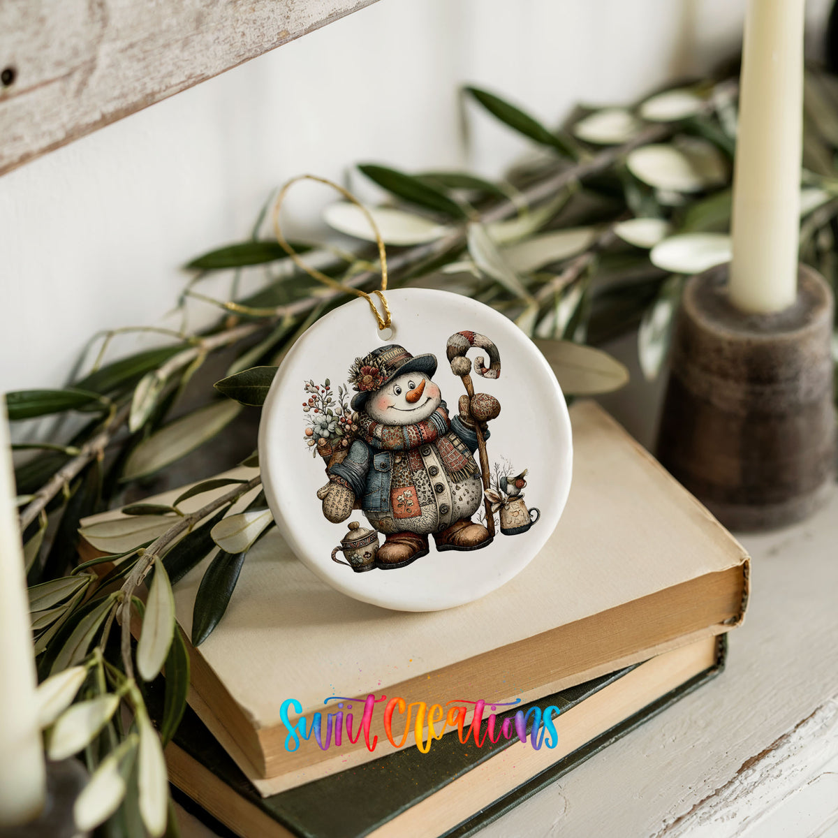 snowman in a brown winter hat holding a candy cane ceramic Christmas ornament styled on stacked books with greenery