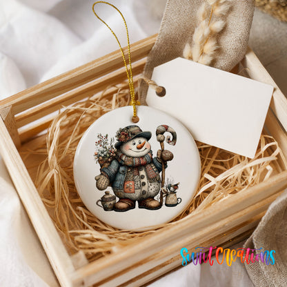 snowman in a brown winter hat holding a candy cane ceramic Christmas ornament displayed in a wooden gift crate