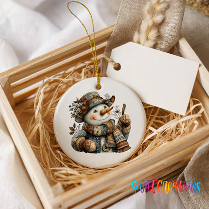 snowman in a brown hat with a winter walking stick ceramic Christmas ornament displayed in a wooden gift crate