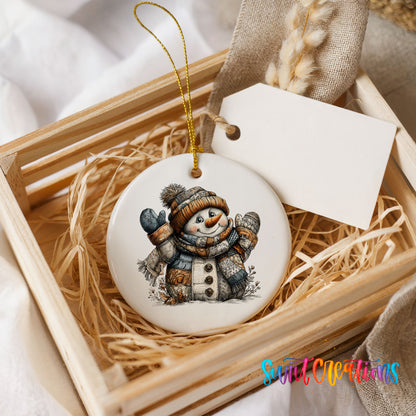 cheerful snowman in a knit hat and blue mittens ceramic Christmas ornament displayed in a wooden gift crate
