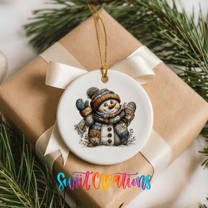 cheerful snowman in a knit hat and blue mittens ceramic Christmas ornament displayed on a wrapped Christmas gift