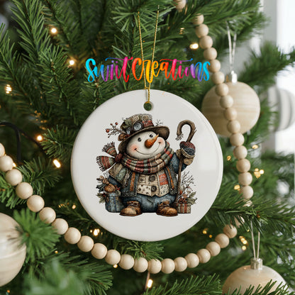 rustic snowman with a walking stick and plaid scarf ceramic Christmas ornament hanging on a green Christmas tree