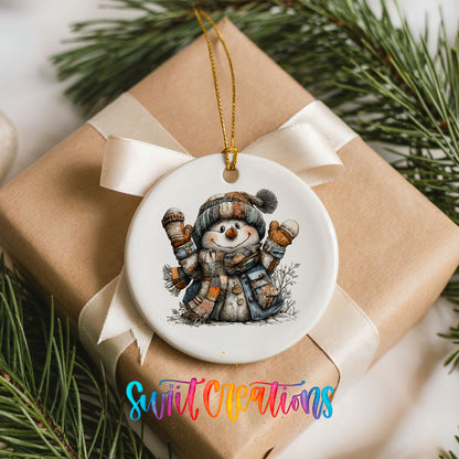 cheerful snowman raising striped winter mittens ceramic Christmas ornament displayed on a wrapped Christmas gift