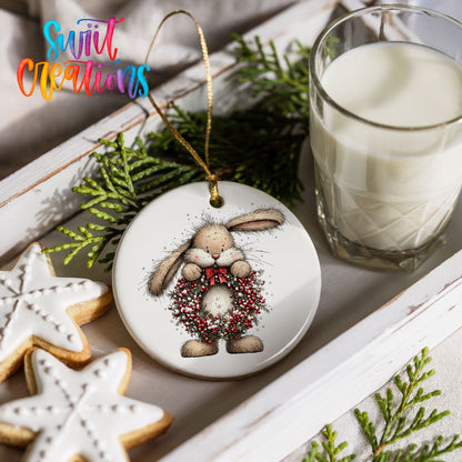 woodland rabbit holding a red berry wreath ceramic Christmas ornament styled with holiday cookies and a candle